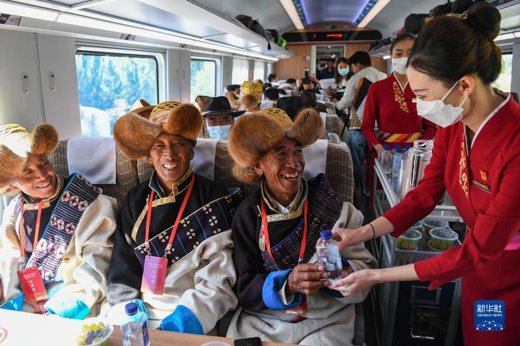 96月25日，全长435公里、设计时速160公里的拉林铁路建成通车，西藏首条电气化铁路建成，同时复兴号实现对31个省区市全覆盖。这是列车员向乘坐首趟复兴号高原内电双源动车组的乘客递水。新华社记者 普布扎西 摄